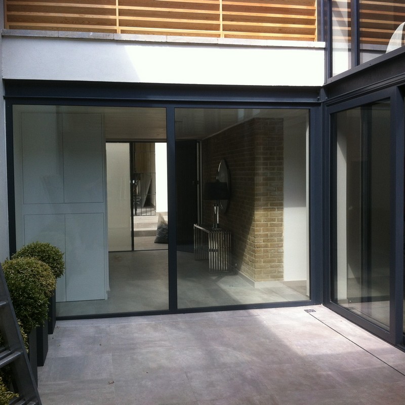 Floor-to-ceiling sliding doors opening to courtyard in South Woodford