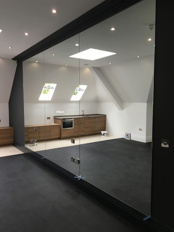 Frameless glass partition in loft conversion by South Woodford glaziers