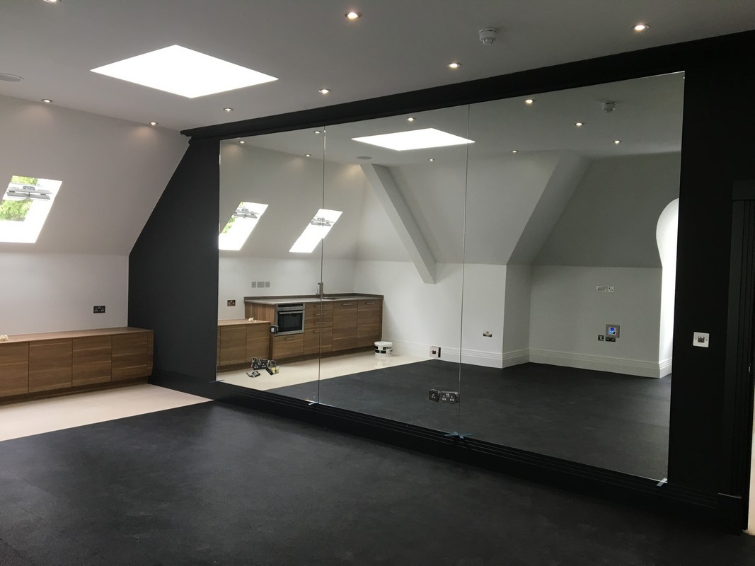 Frameless glass wall dividing loft conversion in South Woodford